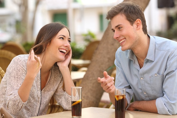 Ein glückliches Paar an einem Tisch im Freien im Gespräch.