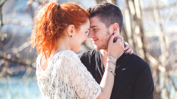 Junges glückliches Paar schaut sich lächelnd in die Augen - Stirn an Stirn - Paar-Kurs für junge Paare